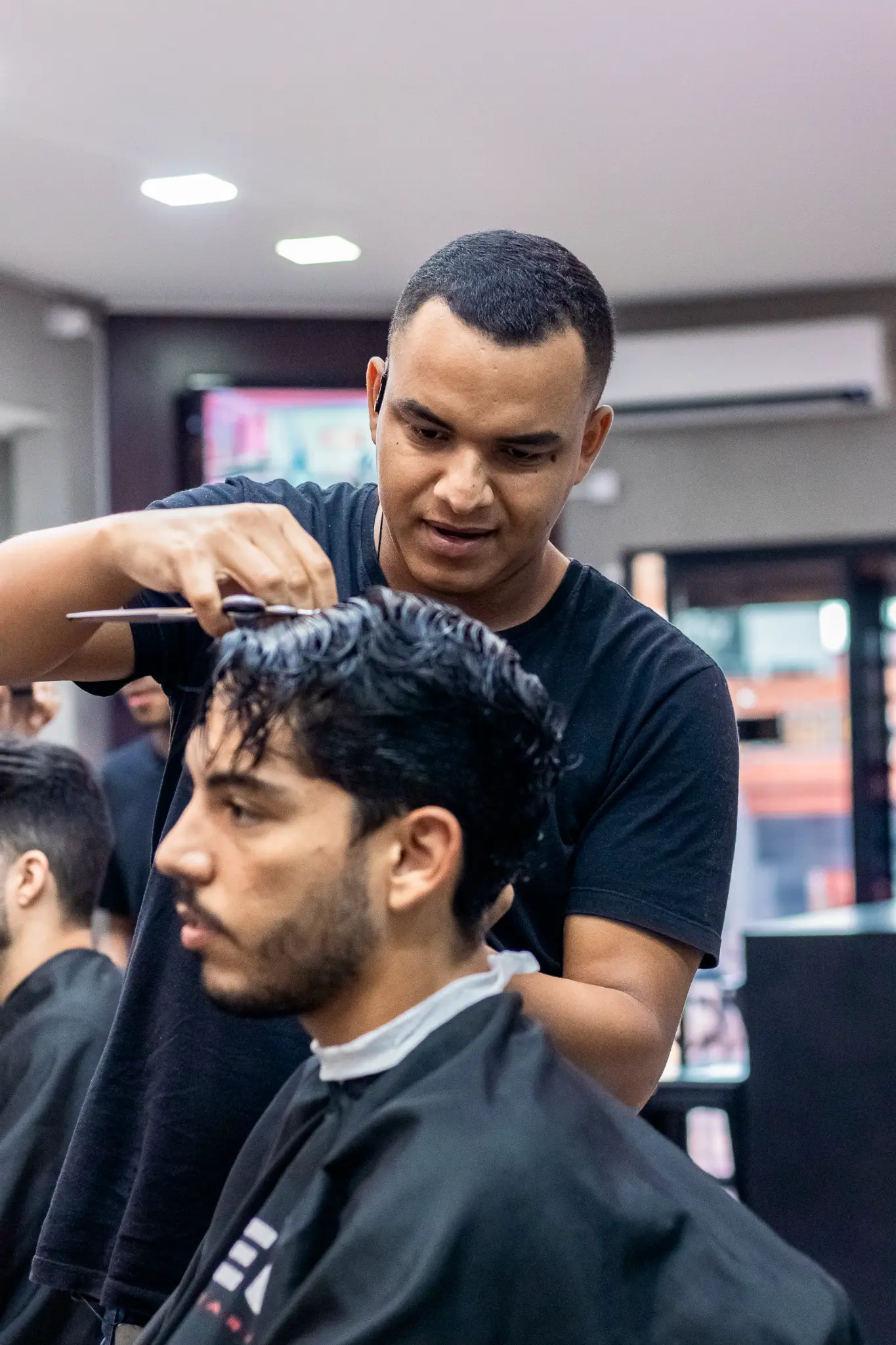 Barbeiro profissional realizando corte de cabelo